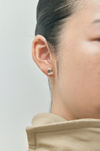 Model wears Clark 2ct emerald cut diamond studs in 18ct yellow gold