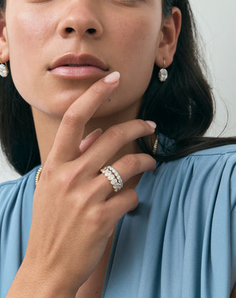 Model wears Cler 0.30ct oval half eternity band in 18ct yellow gold
