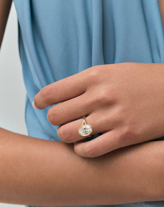 Model wears Sullivan 3ct oval solitaire bezel double band engagement ring in 18ct yellow gold