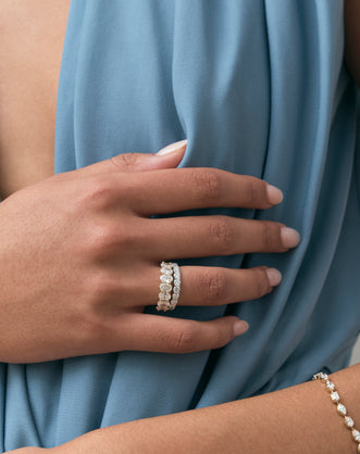 Close-up model wears Cler 0.30ct oval half eternity band in 18ct yellow gold