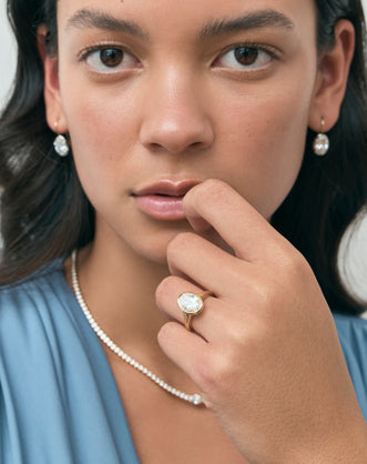 Model wears Sullivan 3ct oval solitaire bezel double band engagement ring in 18ct yellow gold