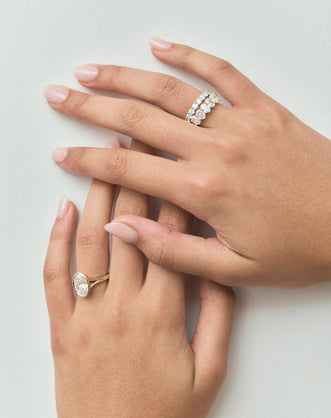 Close-up model wears Cler 0.30ct oval half eternity band in 18ct yellow gold