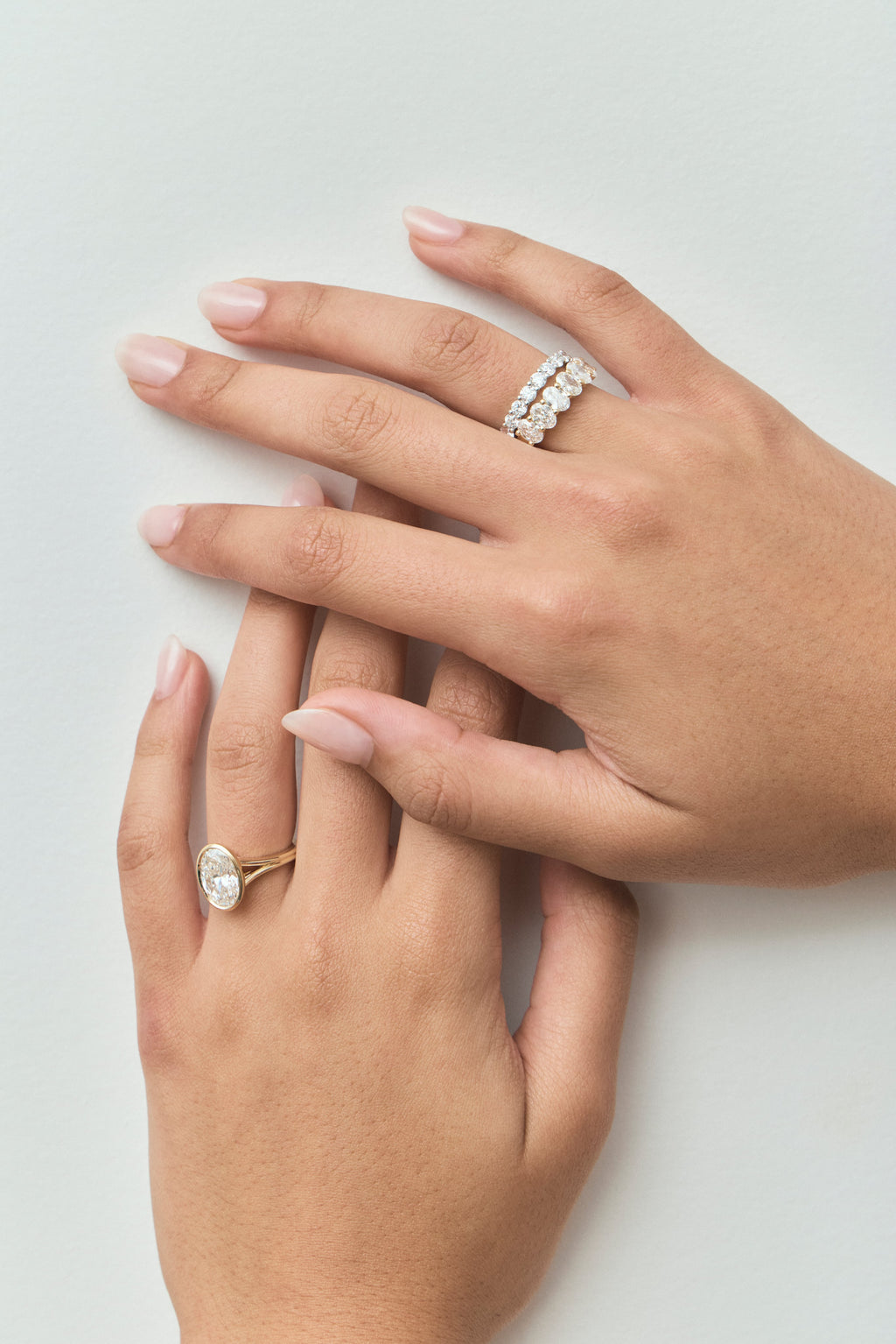Close-up model wears Cler 0.30ct oval half eternity band in 18ct yellow gold