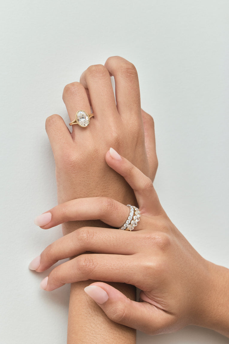 Close-up Sullivan 3ct oval solitaire bezel double band engagement ring in 18ct yellow gold