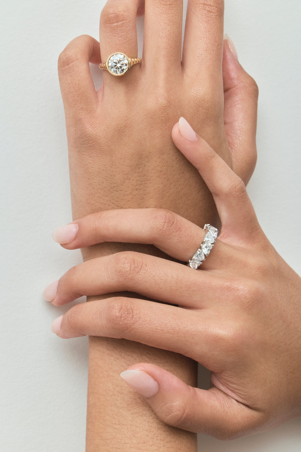 Model wears Chrystie 3ct round brilliant signet bezel grooved band engagement ring in 18ct yellow gold