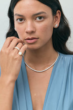 Model wears Moncur 1.5ct pear cut diamond studs in 18ct white gold