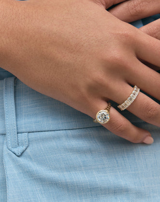 Close-up model wears Soho 0.30ct emerald cut half eternity band in 18ct yellow gold