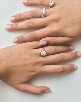Close-up model wears Soho 0.30ct emerald cut half eternity band in 18ct yellow gold