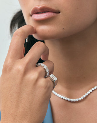 Model wears Cheyne 0.50ct round brilliant half eternity band in platinum 