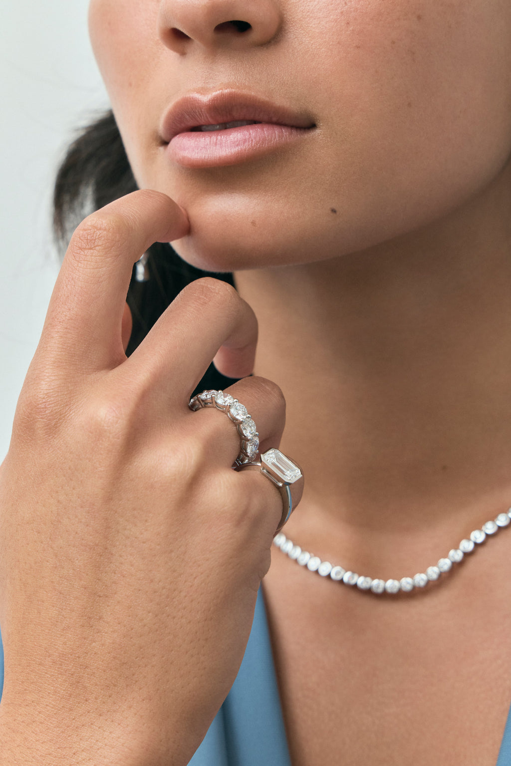 Model wears Cheyne 0.50ct round brilliant half eternity band in platinum 