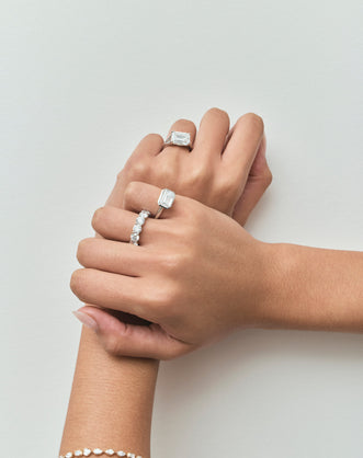 Close-up model wears Cheyne 0.50ct round brilliant half eternity band in 18ct white gold
