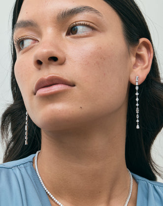 Model wears Tribeca mixed shape statement drop earrings in 18ct white gold