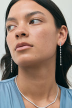 Model wears Tribeca mixed shape statement drop earrings in 18ct white gold