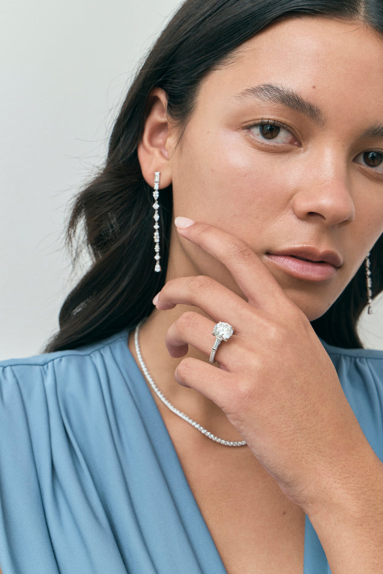 Model wears Hudson 4ct round brilliant tapered baguette engagement ring in platinum