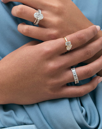 Model wears Montaigne oval solitaire swept shoulder engagement ring in platinum