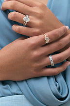Model wears Montaigne oval solitaire swept shoulder engagement ring in platinum