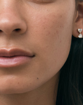 Model wears Notting romantic pair double 0.50ct heart shape drop earrings in 18ct yellow gold