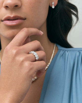Close-up model wears Cler 0.50ct oval half eternity band in 18ct white gold