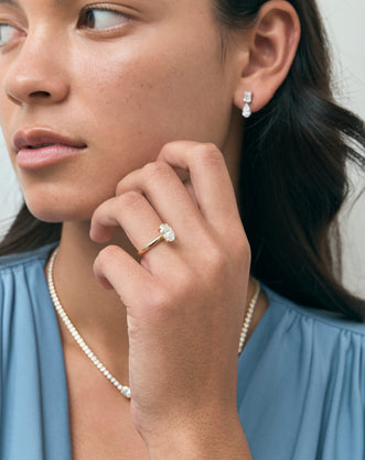 Model wears Florence oval solitaire classic engagement ring in 18ct yellow gold