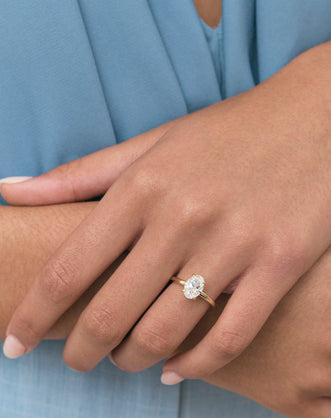 Model wears Florence oval solitaire classic engagement ring in 18ct yellow gold