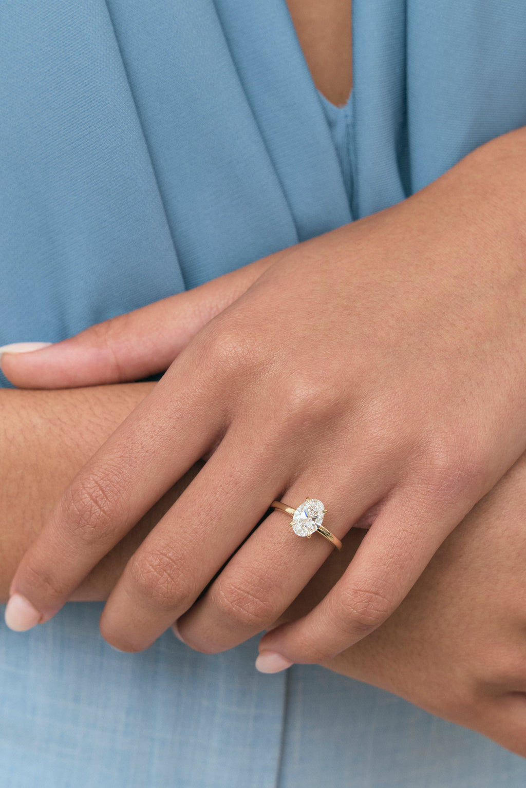 Model wears Florence oval solitaire classic engagement ring in 18ct yellow gold
