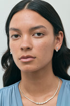 Model wears Madame 0.50ct emerald pear cut drop earrings in 18ct white gold