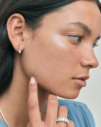 Model wears Madame 0.50ct emerald pear cut drop earrings in 18ct white gold