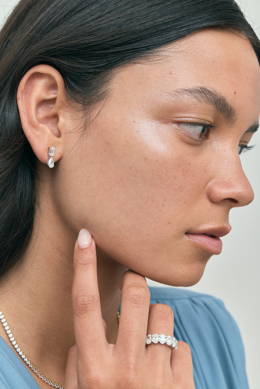 Model wears Madame 0.50ct emerald pear cut drop earrings in 18ct white gold