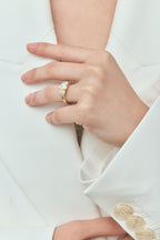 Model wears Clarkson oval trilogy engagement ring in 18ct yellow gold