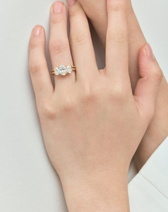Model wears Clarkson oval trilogy engagement ring in 18ct yellow gold