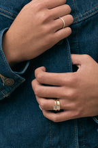 Model wears Sutton emerald cut solitaire bezel north-south engagement ring in 18ct yellow gold