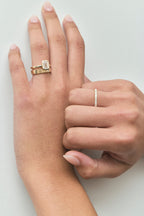 Close-up Sutton emerald cut solitaire bezel north-south engagement ring in 18ct yellow gold