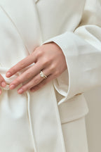 Model wears Maddox oval solitaire bezel east-west engagement ring in 18ct yellow gold