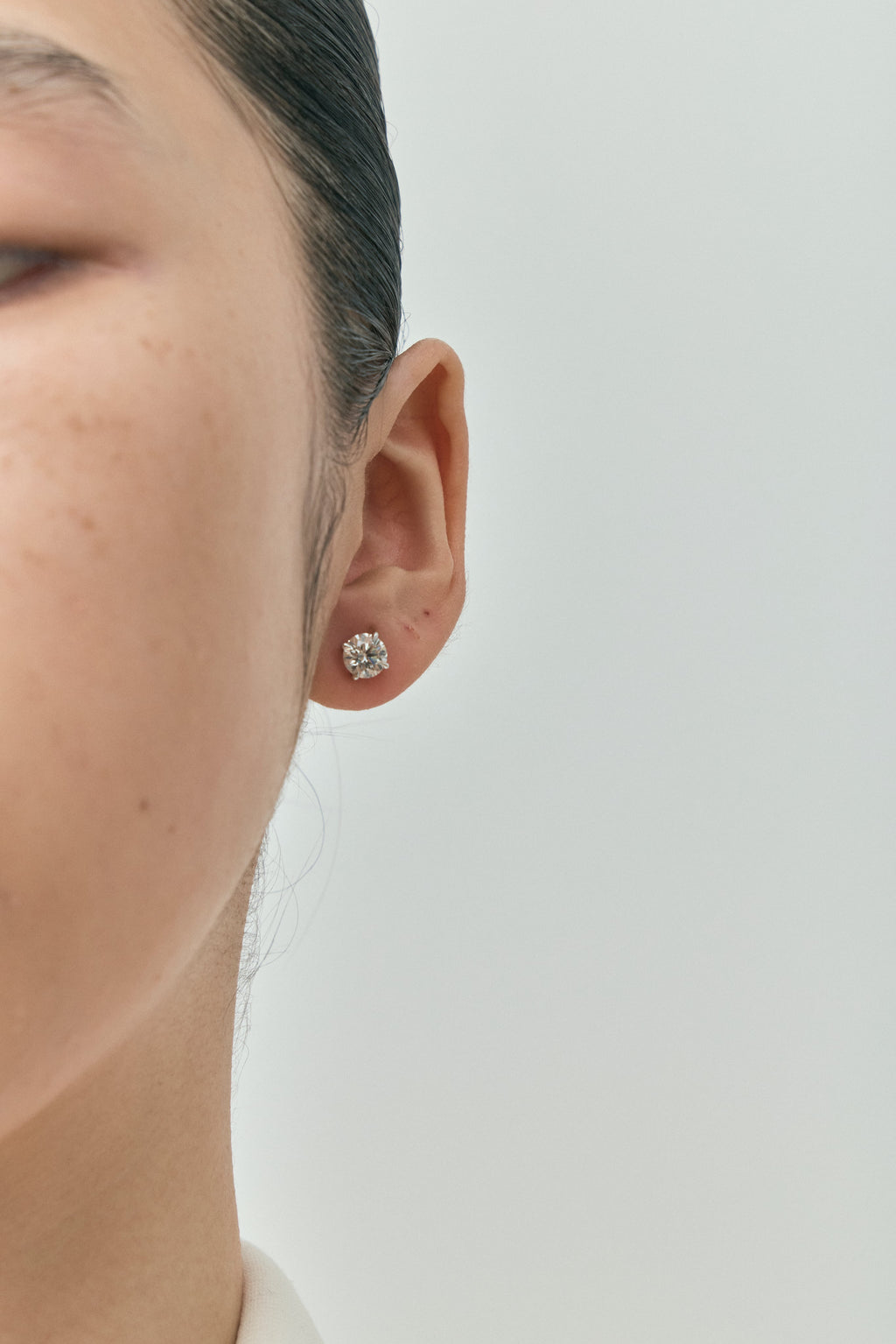 Model wears Dean 1ct round brilliant cut diamond studs in 18ct white gold