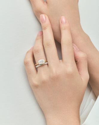 Close-up Maddox oval solitaire bezel east-west engagement ring in 18ct yellow gold