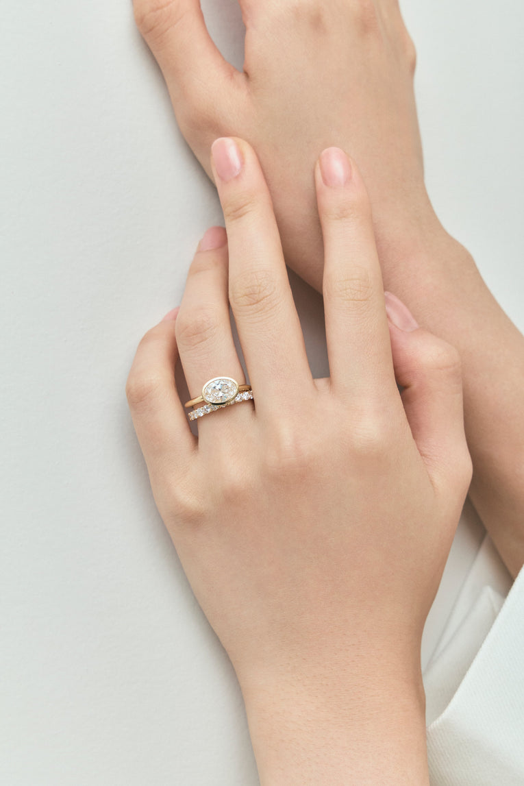Close-up Maddox oval solitaire bezel east-west engagement ring in 18ct yellow gold