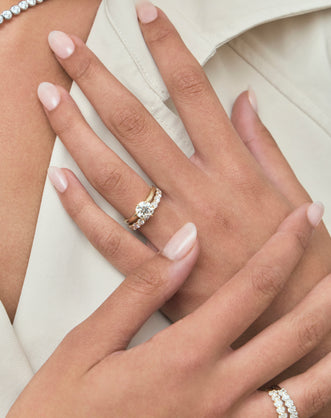 Model wears Oxford round brilliant six claw solitaire classic engagement ring in 18ct yellow gold