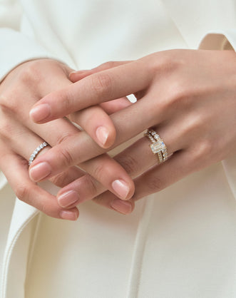 Model wears Beverly emerald cut diamond band engagement ring in 18ct yellow gold 