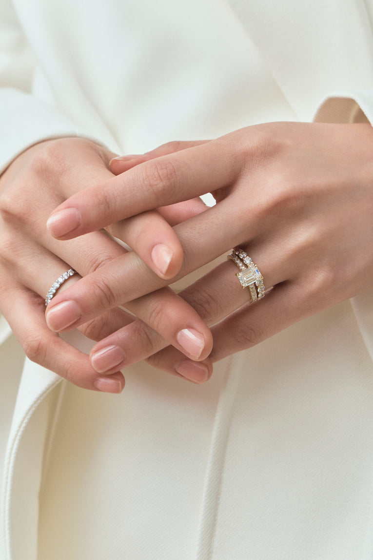 Model wears Beverly emerald cut diamond band engagement ring in 18ct yellow gold 