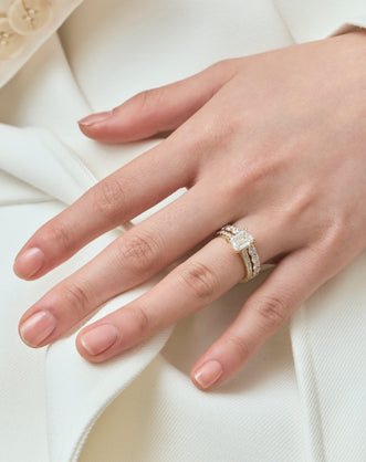 Model wears Beverly emerald cut diamond band engagement ring in 18ct yellow gold 
