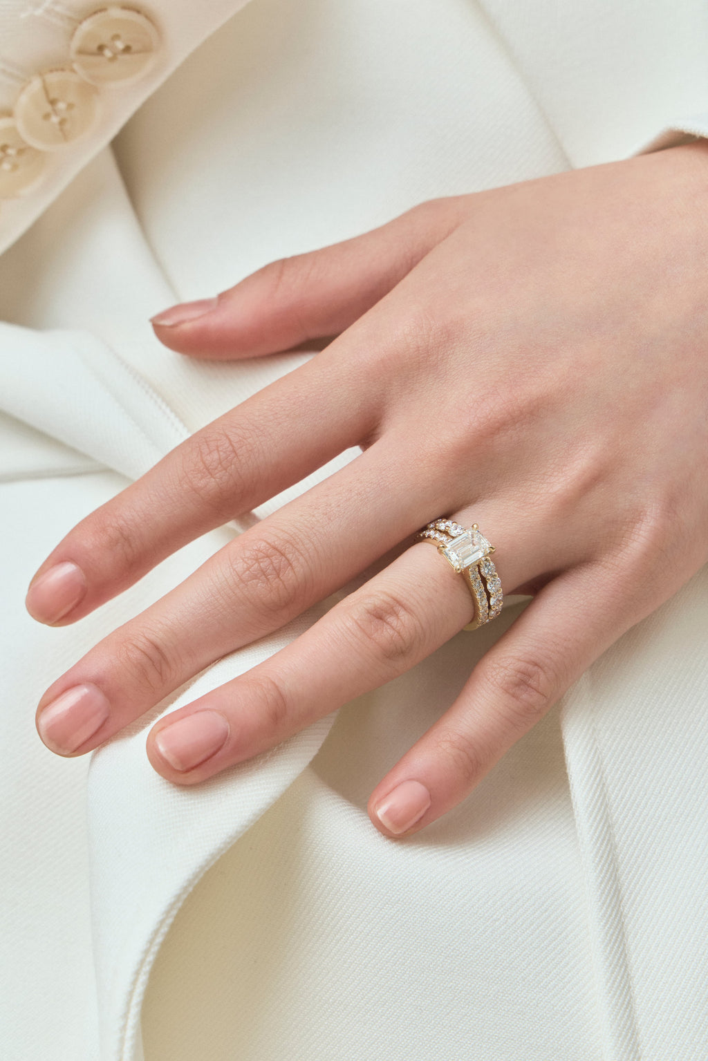 Model wears Beverly emerald cut diamond band engagement ring in 18ct yellow gold 