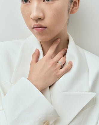 Model wears Paddington 2.4mm round brilliant half set wedding band in platinum