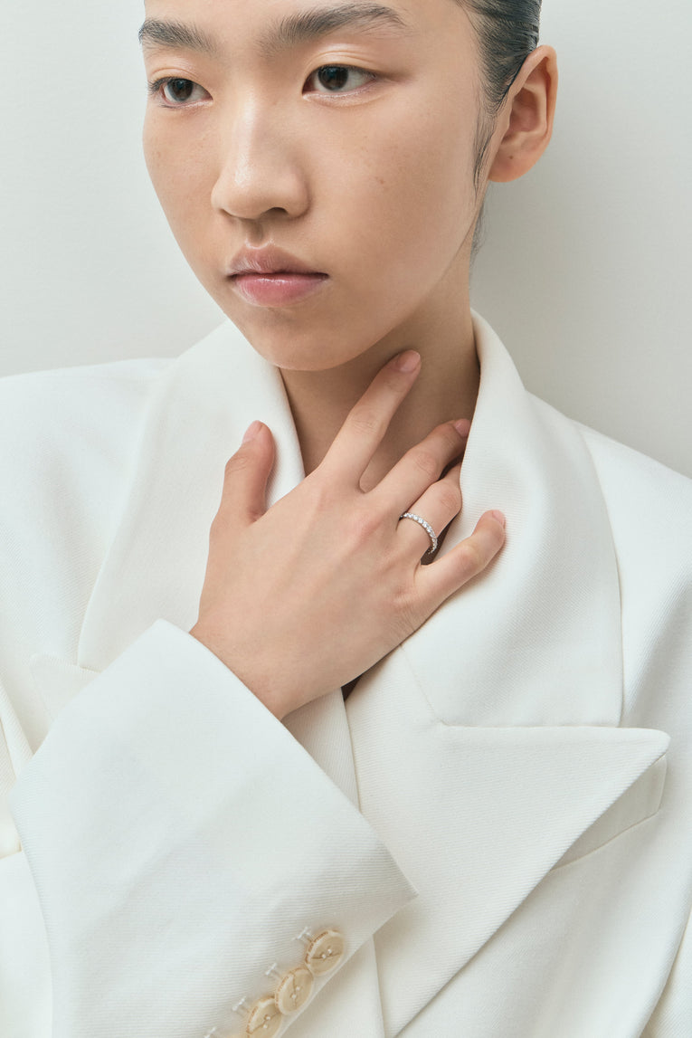 Model wears Paddington 2.4mm round brilliant half set wedding band in platinum