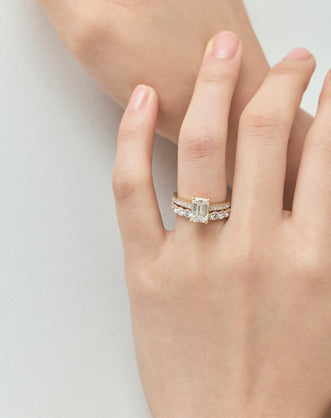 Model wears Beverly emerald cut diamond band engagement ring in 18ct yellow gold 