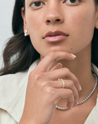 Model wears Tournon 0.20ct oval bezel set half eternity band in 18ct yellow gold