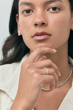 Model wears Tournon 0.20ct oval bezel set half eternity band in 18ct yellow gold