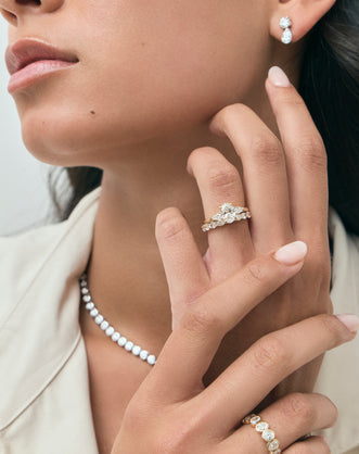 Model wears Bonaparte oval pear side stone engagement ring in 18ct yellow gold