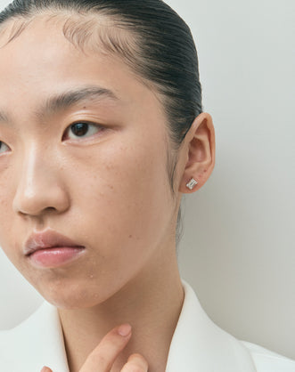 Model wears Chelsea 1ct emerald cut diamond studs in 18ct white gold