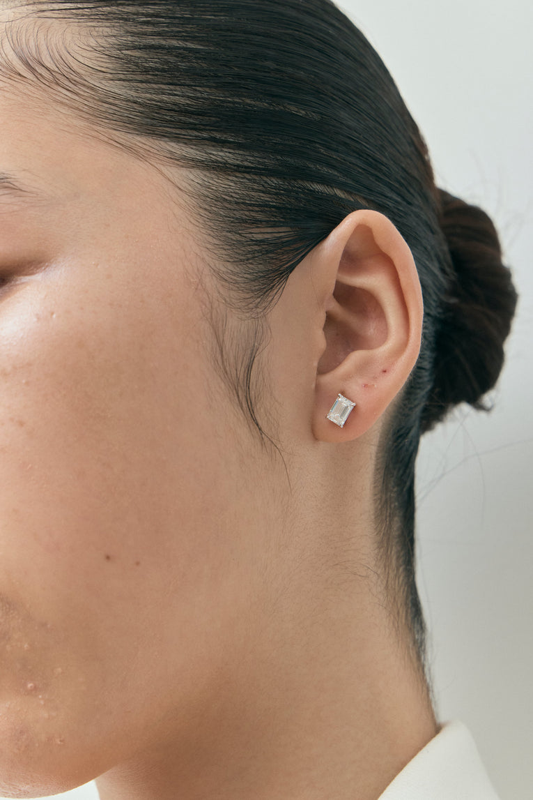 Model wears Chelsea 1ct emerald cut diamond studs in 18ct white gold