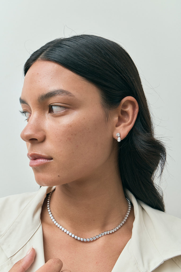 Model wears Saville 0.50ct round brilliant pear cut drop earrings in 18ct white gold